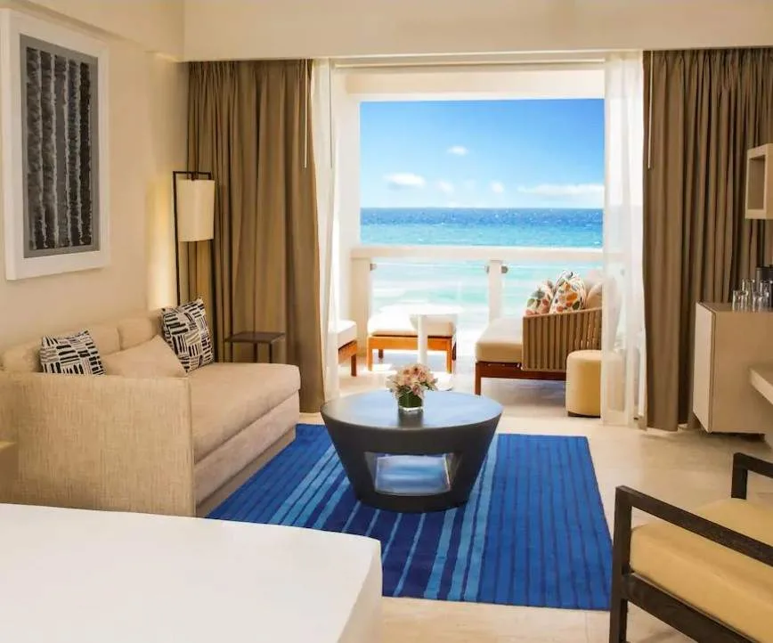 resort room with been looking out onto ocean through huge window