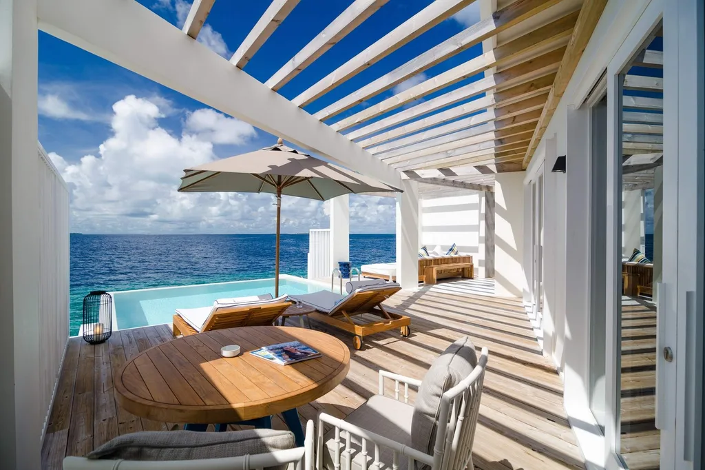 covered patio with round tables and chair overlooking ocean