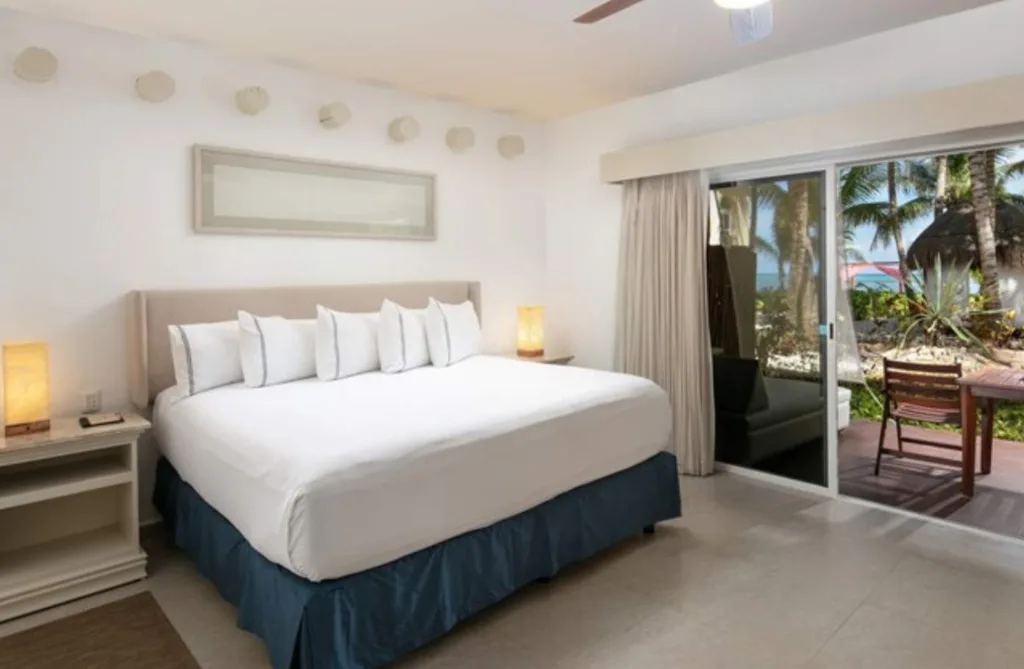 white bed with sliding window leading outside