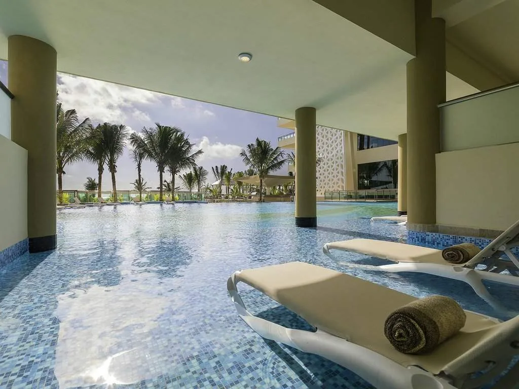 spa chairs in pool looking at palm trees
