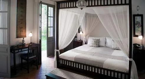 white beds with wood posts and white cloth