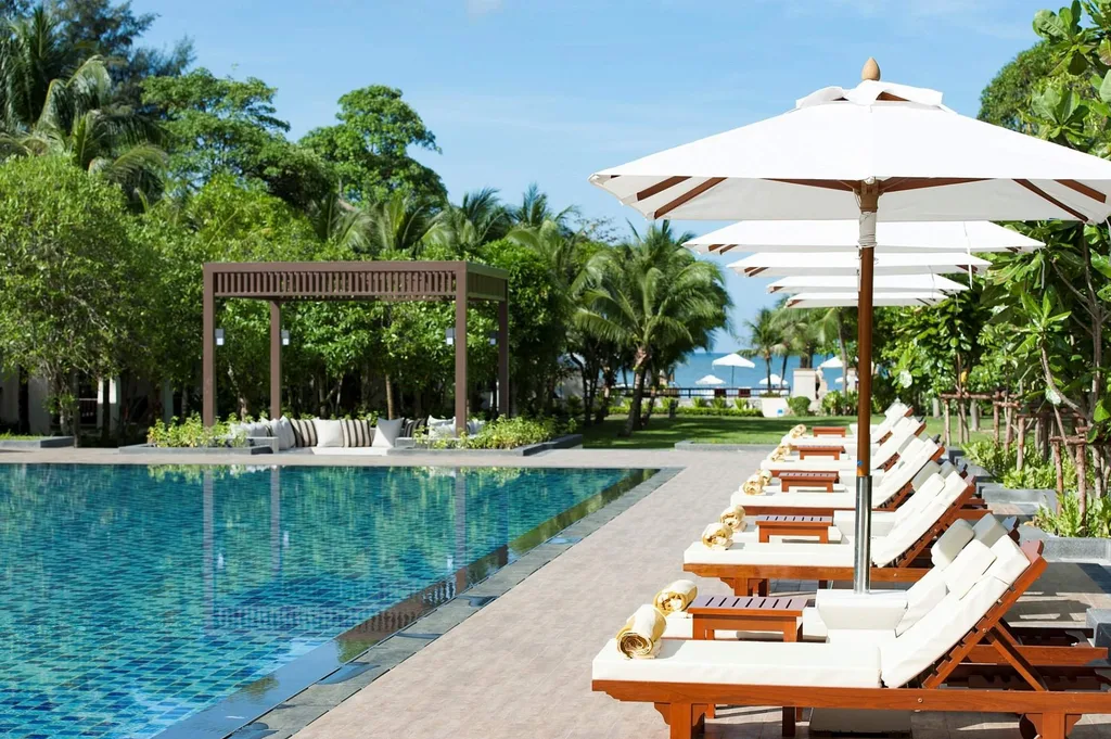 white folding chairs with white umbrellas surrounding square pool
