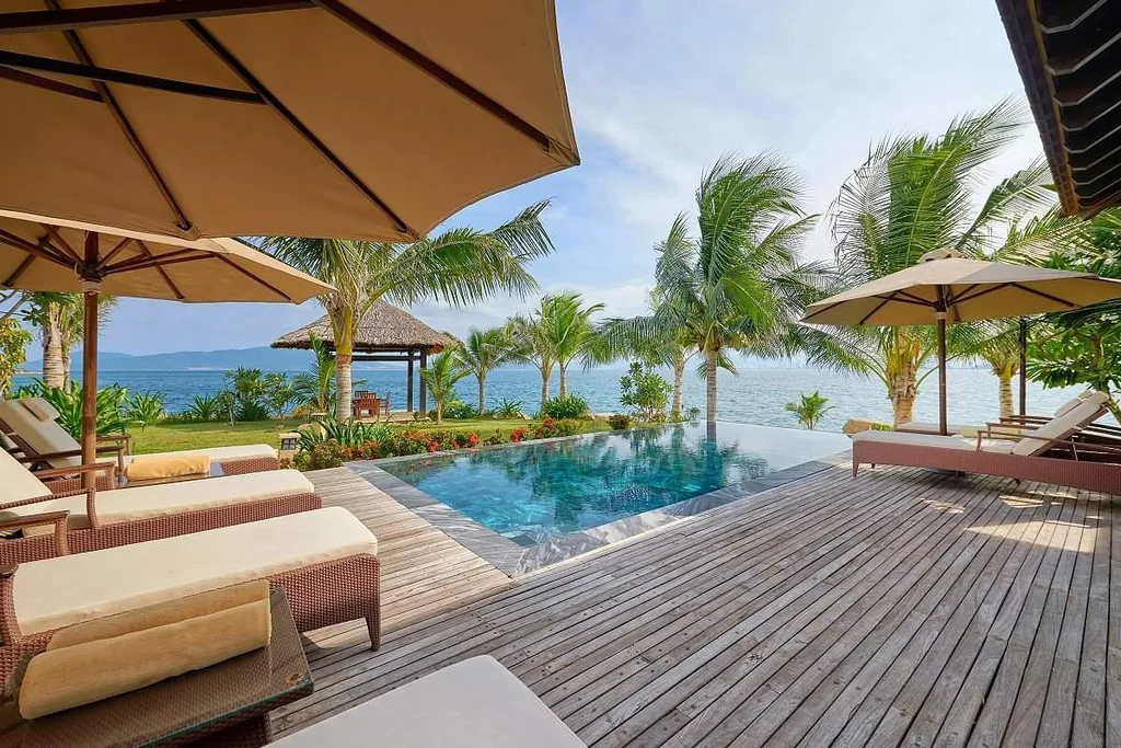 resort infinity pool in front of 4 lawn chairs and umbrellas