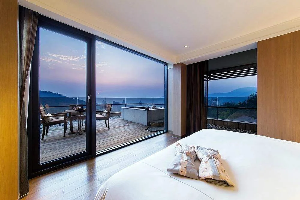 resort room with floor to ceiling window at dusk