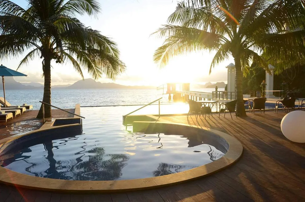 circular infinity pool in front of ocean surrounded by palm trees