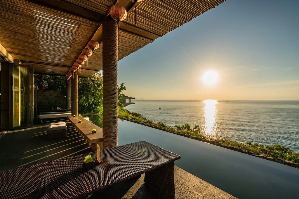 sun setting on water in front of resort infinity pool