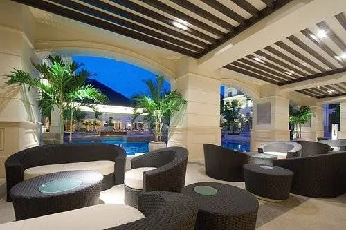 chairs under covered patio in front of resort pool
