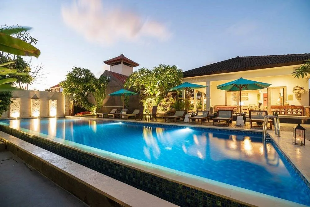 rectange pool with 3 umbrellas over lounge chairs