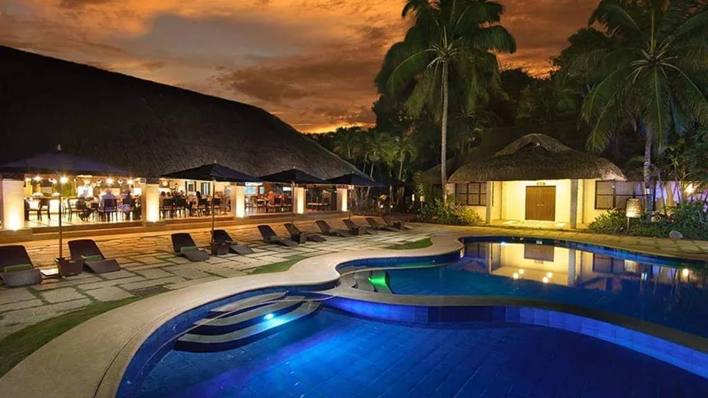 outdoor resort restaurant in front of large round pool at sunset