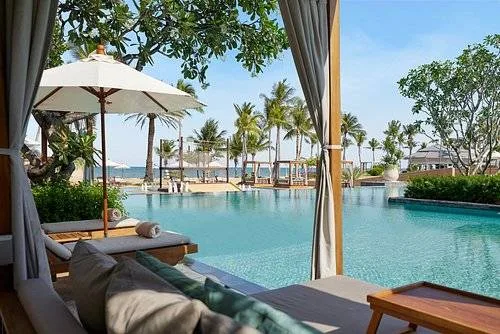 large square resort pool surrounded by cabanas