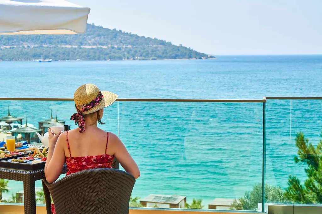 woman sitting in front of infinity pool overlooking ocean