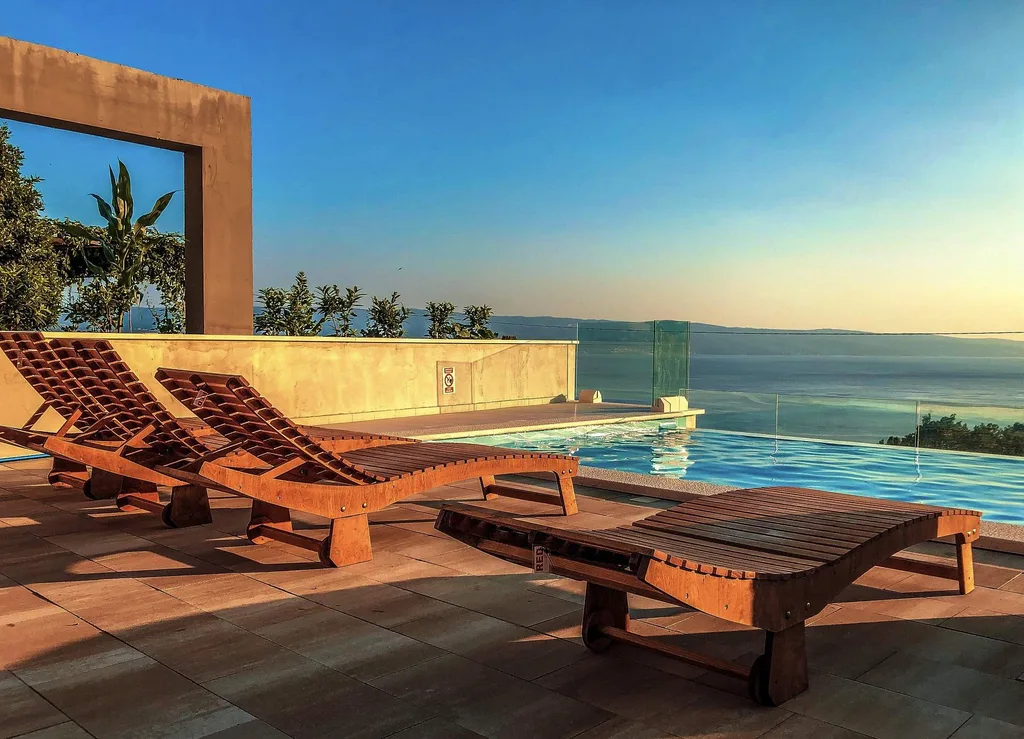 4 wooden lounge chairs in front of infinity pool
