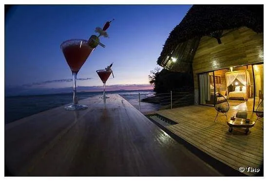 2 cocktail glasses on ledge at dusk