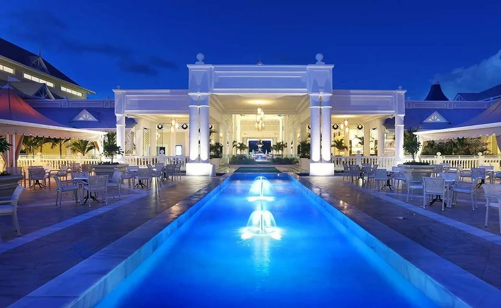 long pool in front of building at night