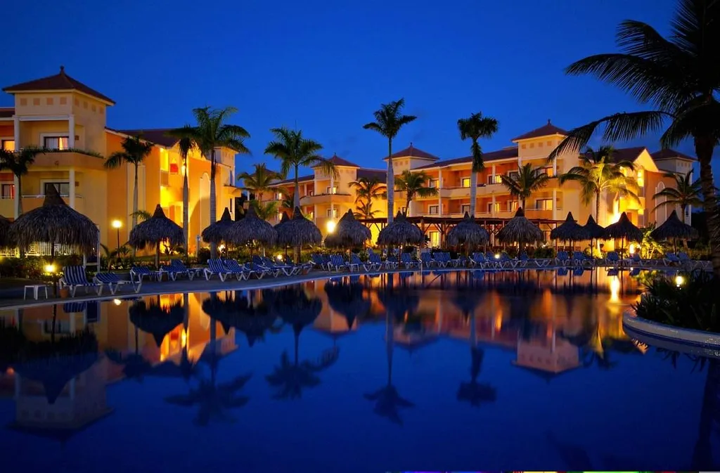 resort buildings with palm trees at night