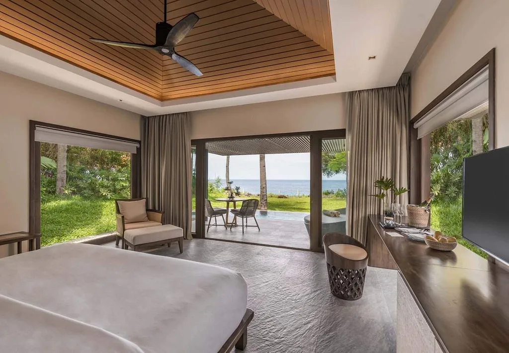 bed room at tropical resort with floor to ceiling windows