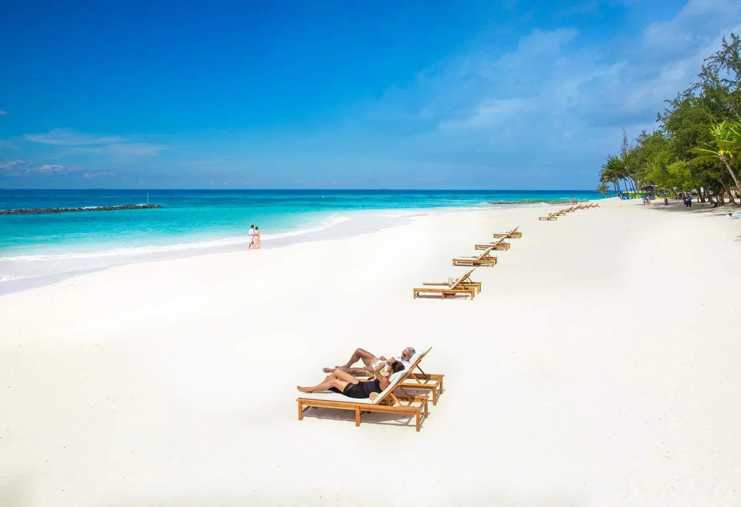 long white sand beach with many lounge chairs