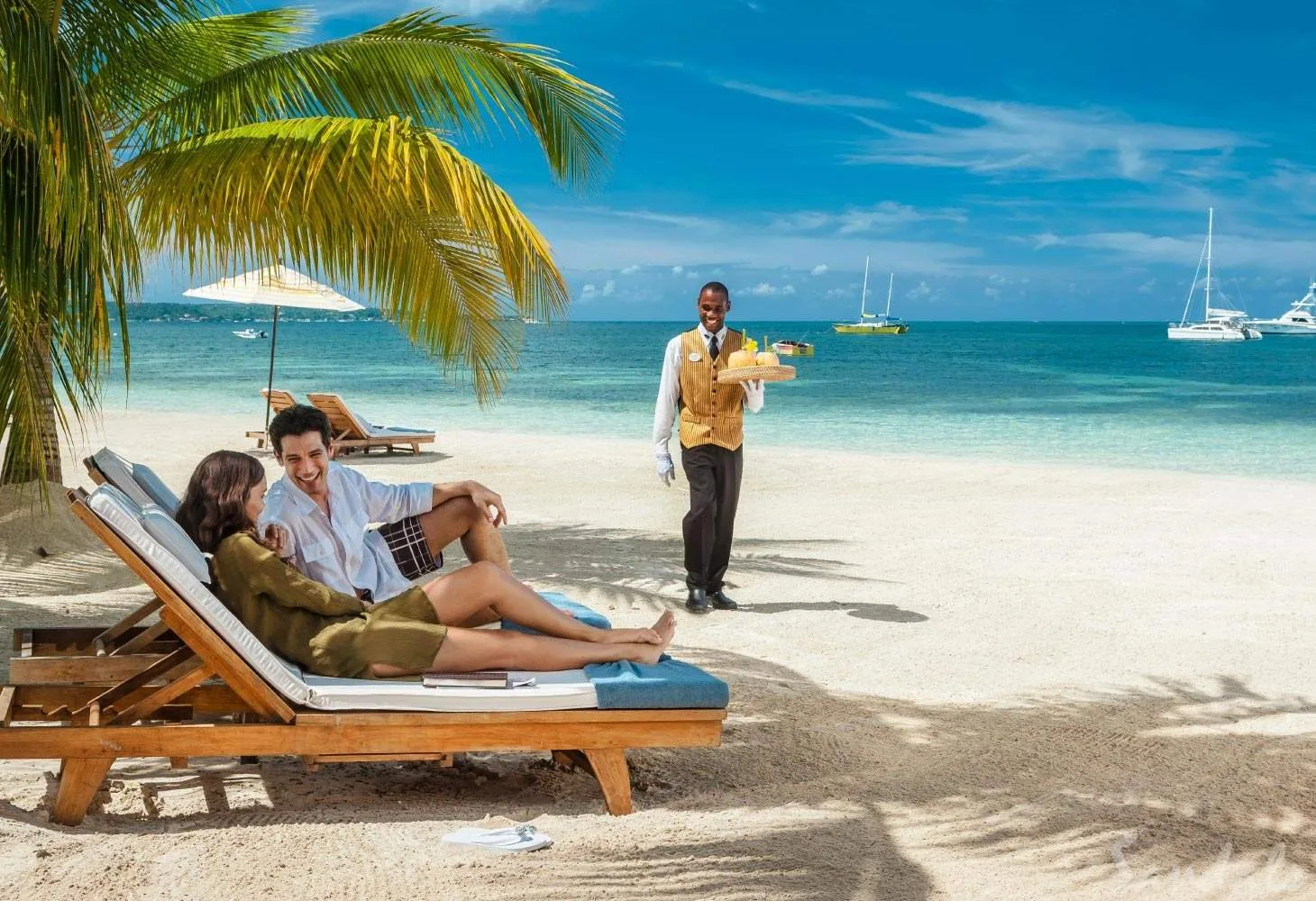butler serving couple on beach