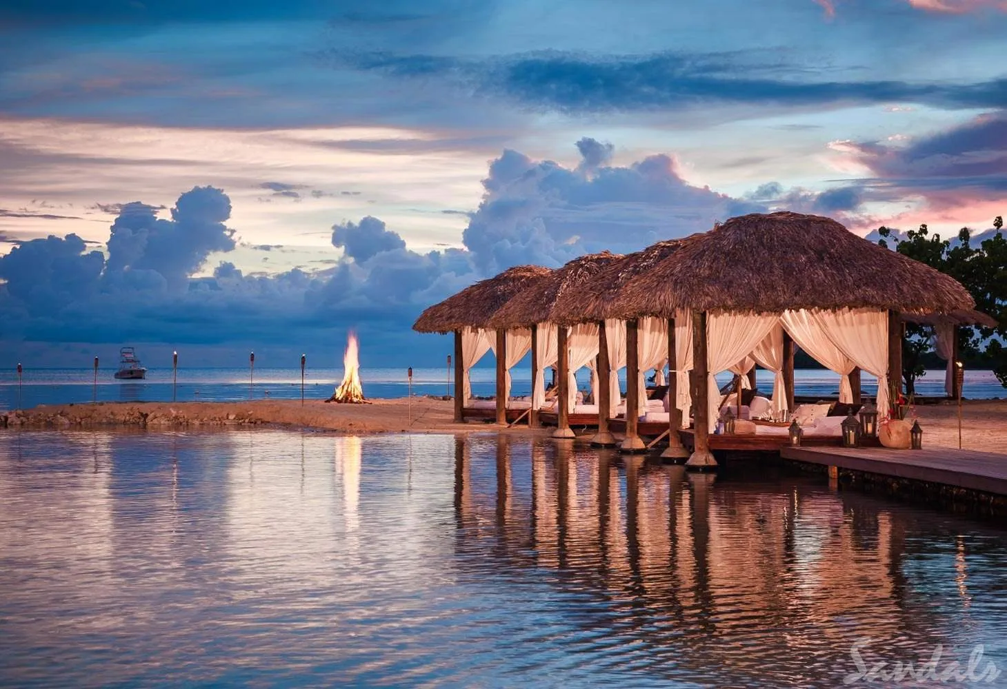 five cabanas on beach at dusk