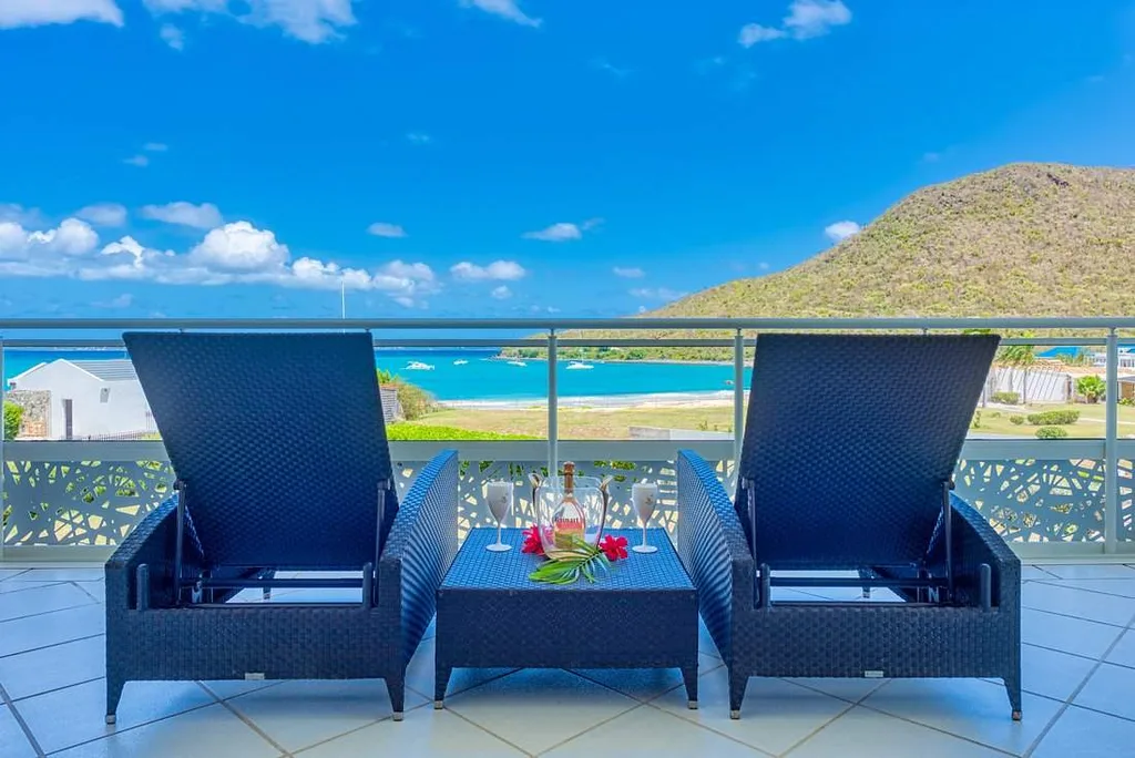 two lounge chairs on balcony looking out to ocean