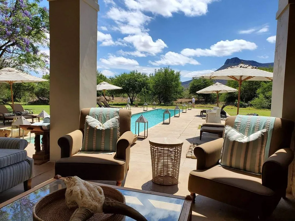 chairs under patio with pool in backgound