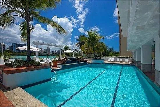 square resort swimming pool with palm trees