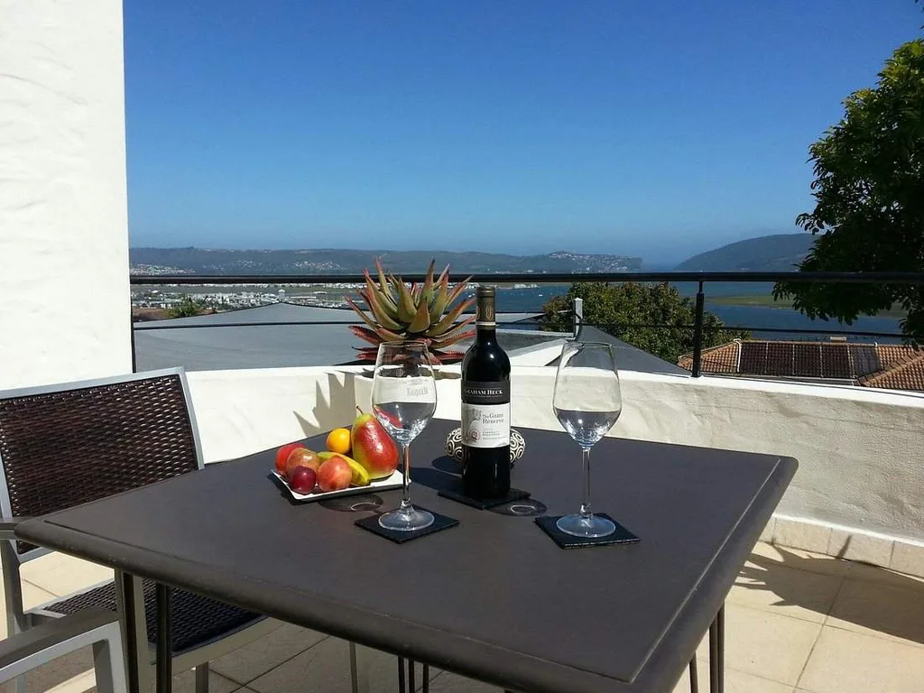 square table with wine glass overlooking water
