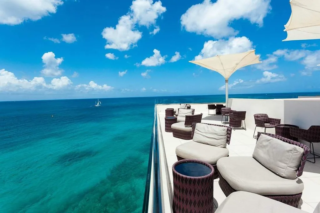 ocean surrounding patio with lounge chairs