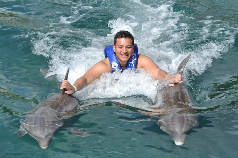 man riding with two dolphins