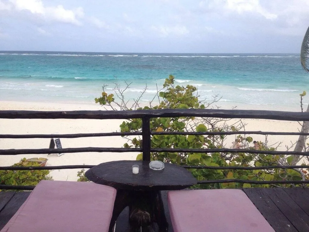two resort lounge chairs on patio over beach