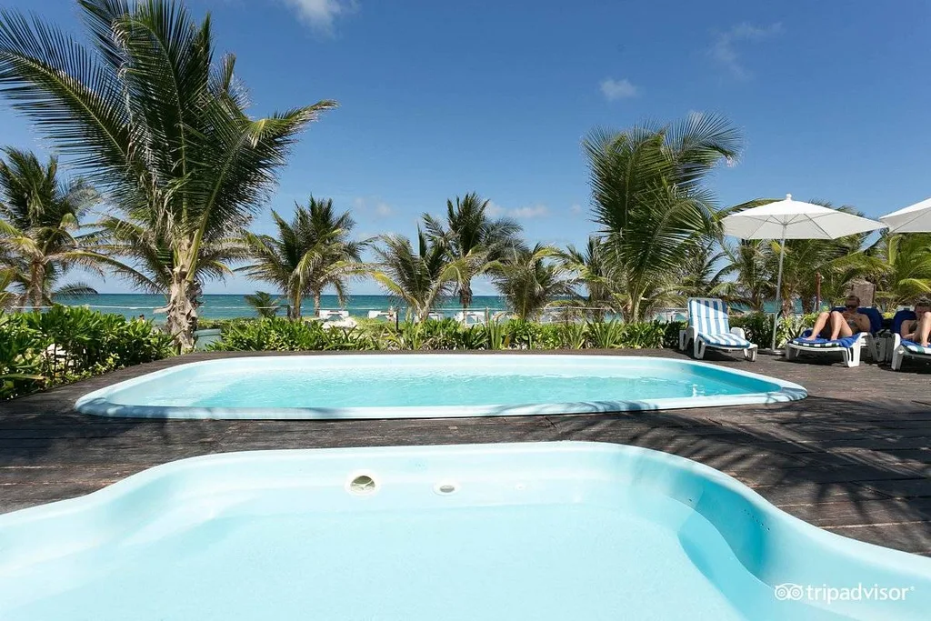 two resort pools surrounded by palm trees