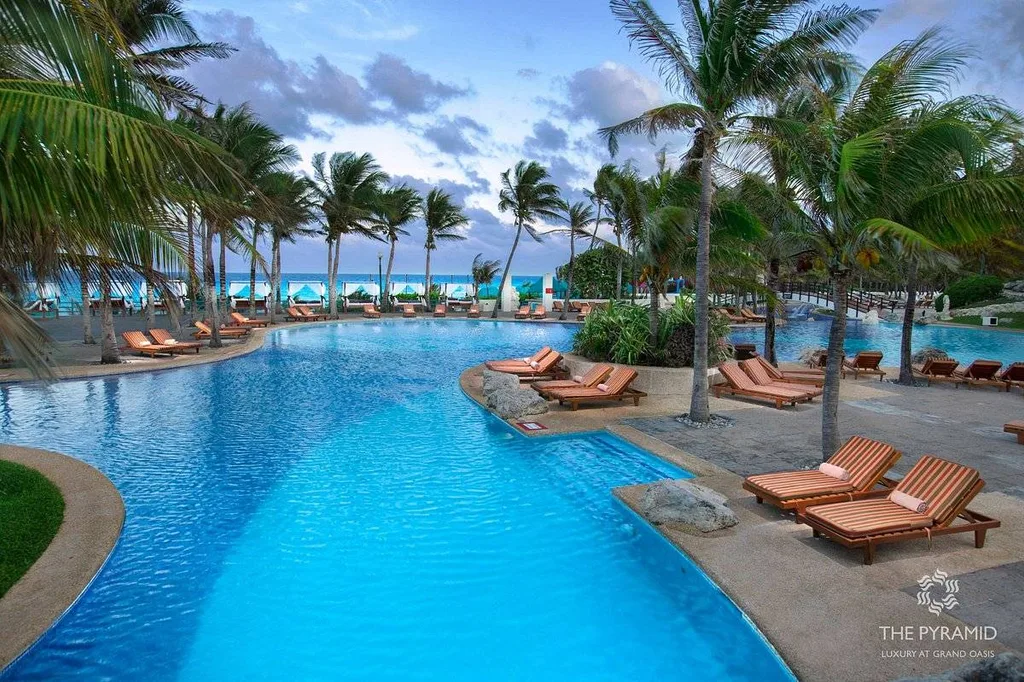 large resort pool surrounded by palm trees