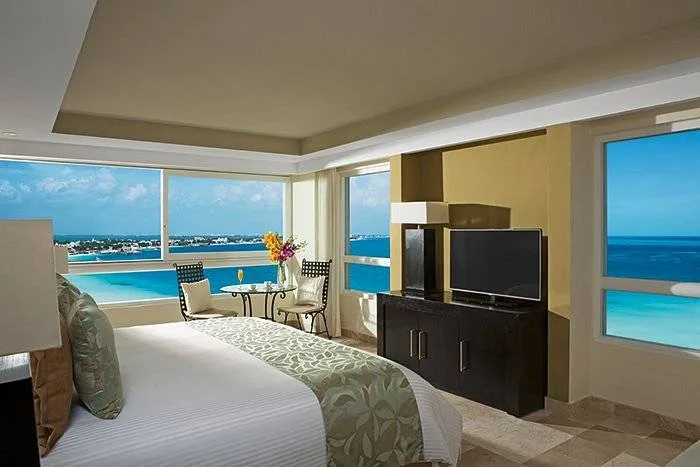 resort room with bed and windows on 2 walls