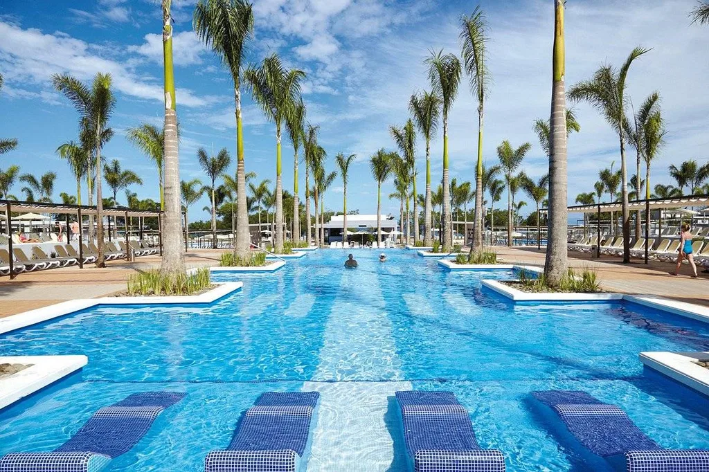 long rectangular resort pool with palm trees lining both sides