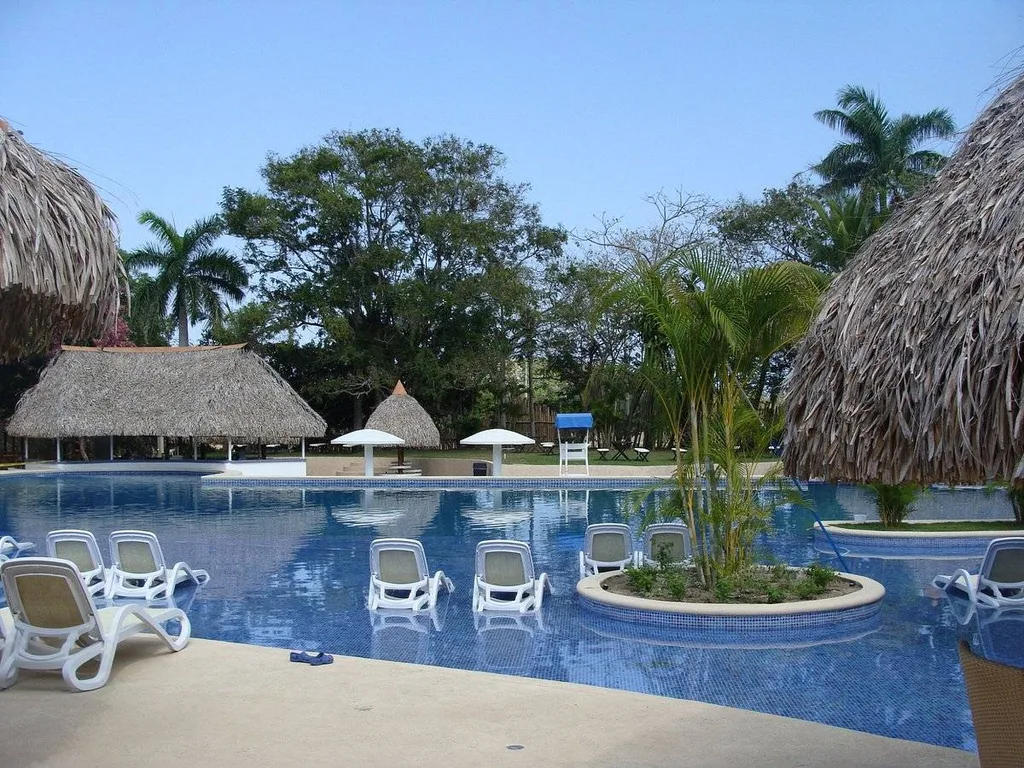 tropical resort pool surrounded by huts