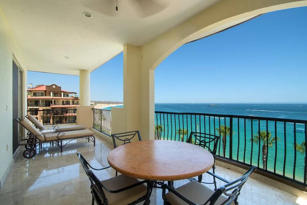 table with chairs on private balcony overlooking ocean