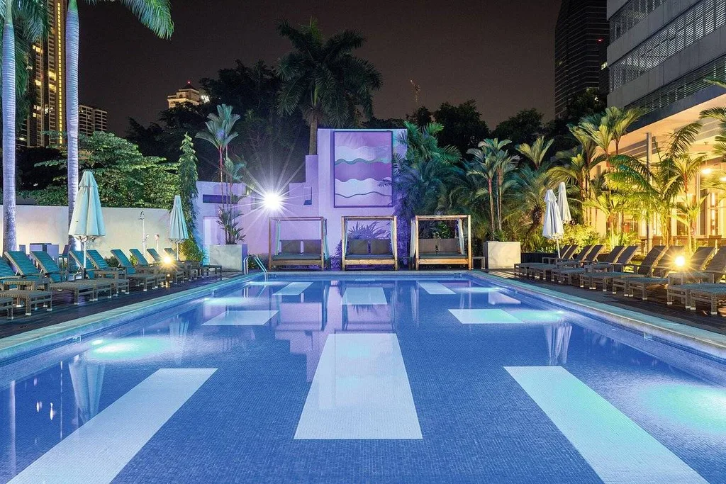 resort pool at night lined by lounge chairs