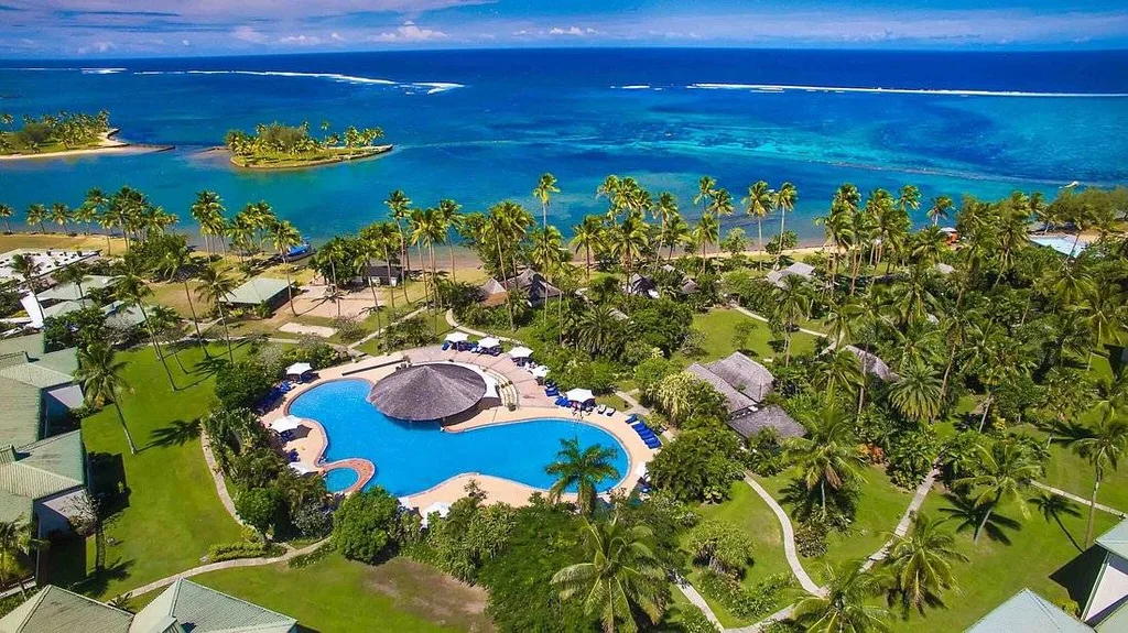 aerial view of resort pool surrounded by trees and ocean