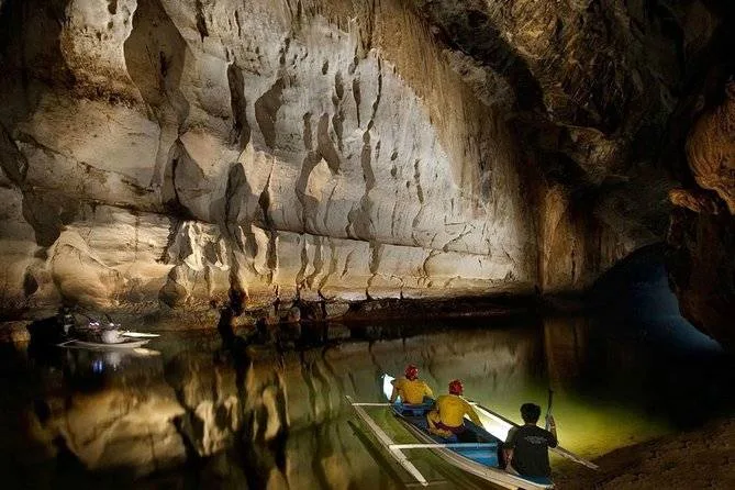 3 people in boat in a cave