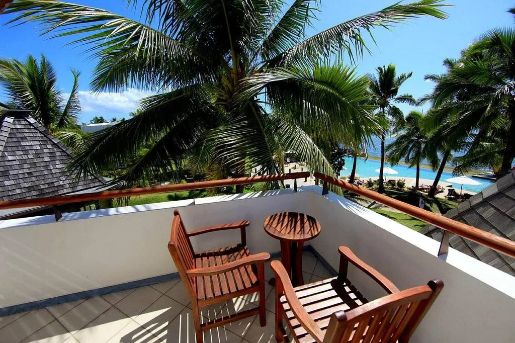 chairs on deck behind large palm tree