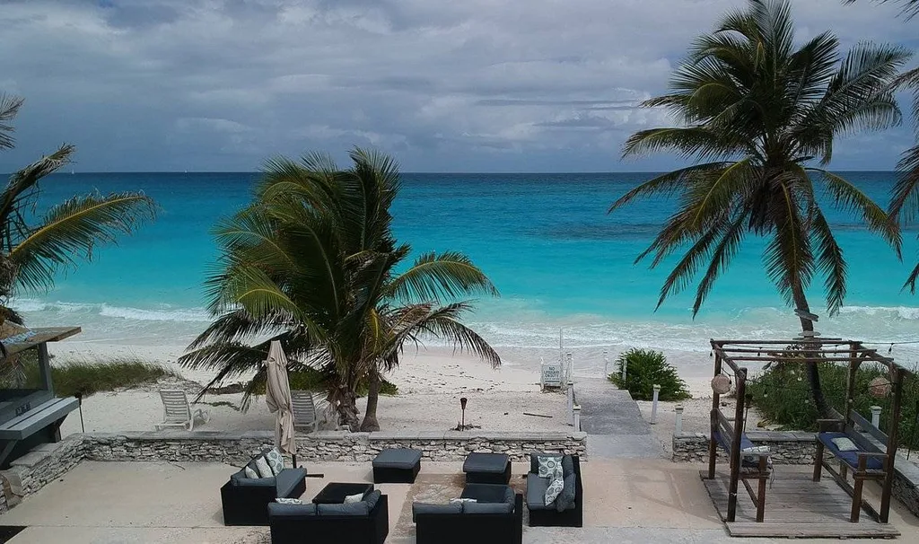 aerial view of beach with furniture and palm trees