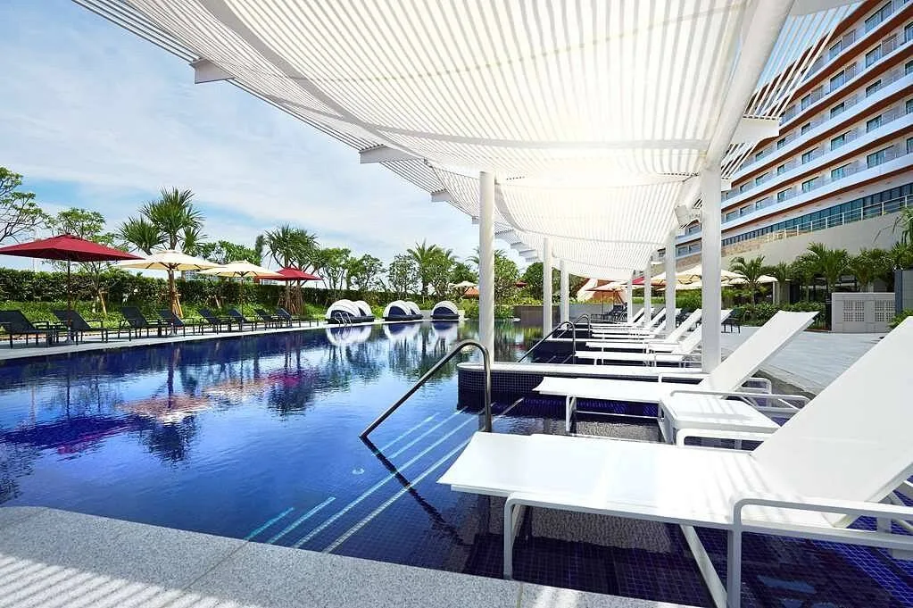 swimming pool lined with white lounge chairs