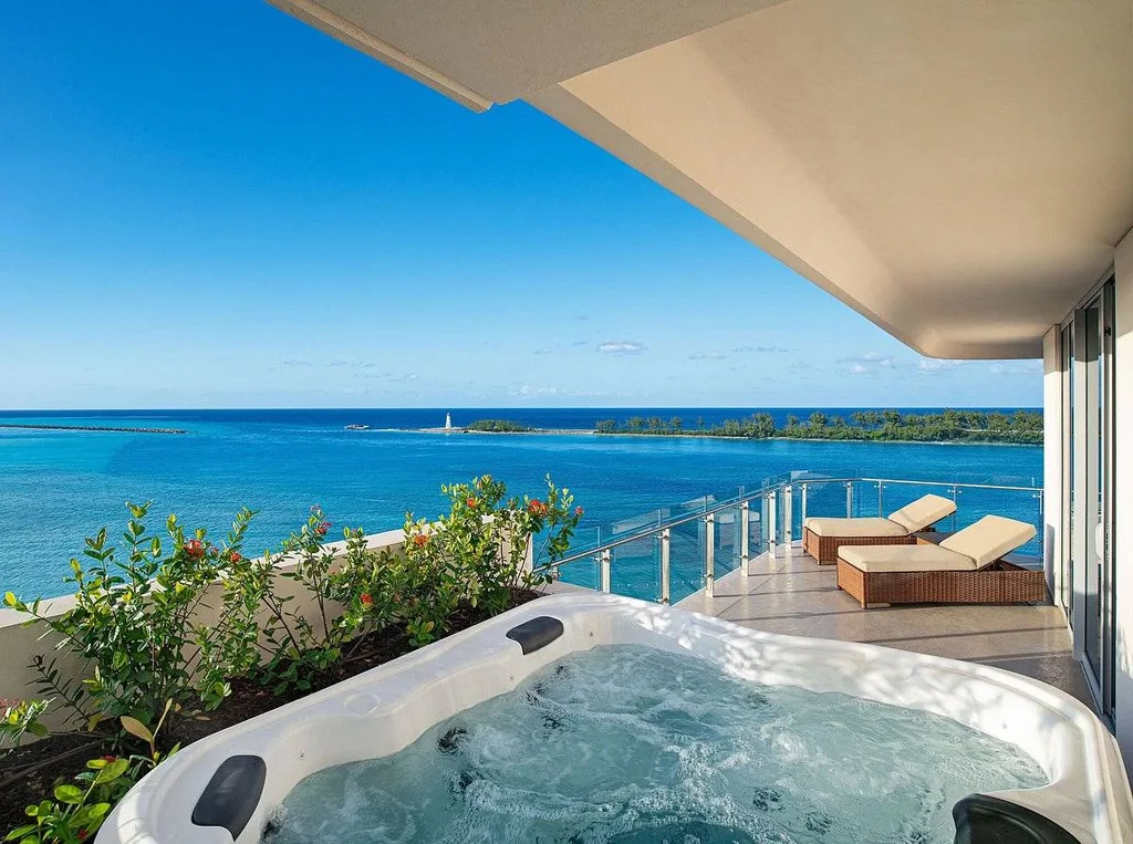 jacuzzi and lounge chairs on deck overlooking ocean