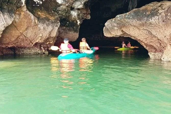 people on canoe going into cave