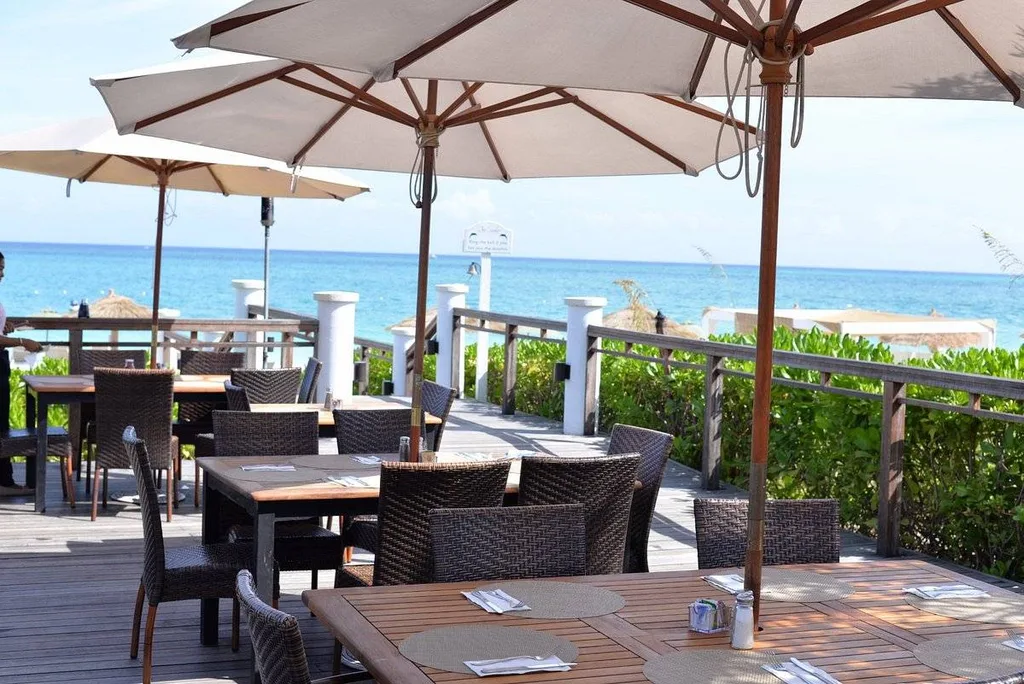 dining tables with umbrellas overlooking ocean