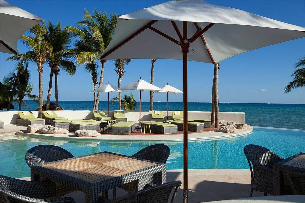 ocean resort pool with tables and umbrellas