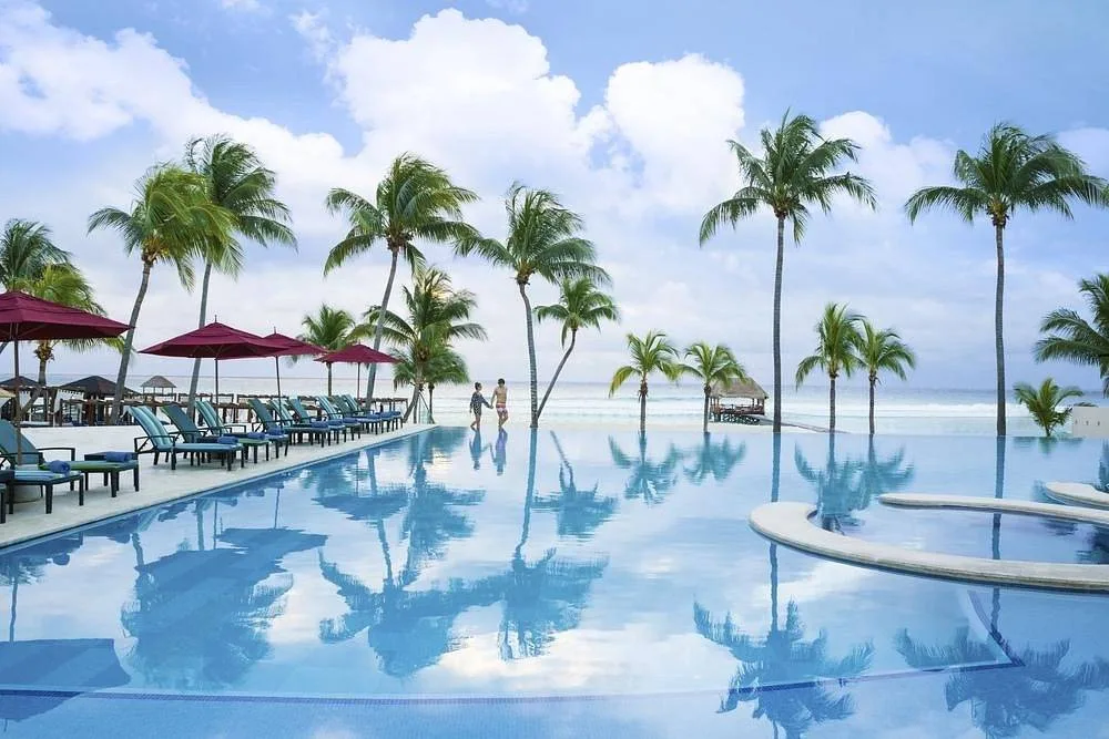 crystal clear resort pool with palm trees at the beach