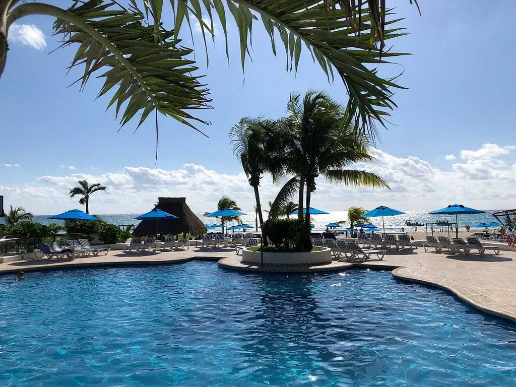 resort pool surrounded by blue umbrellas