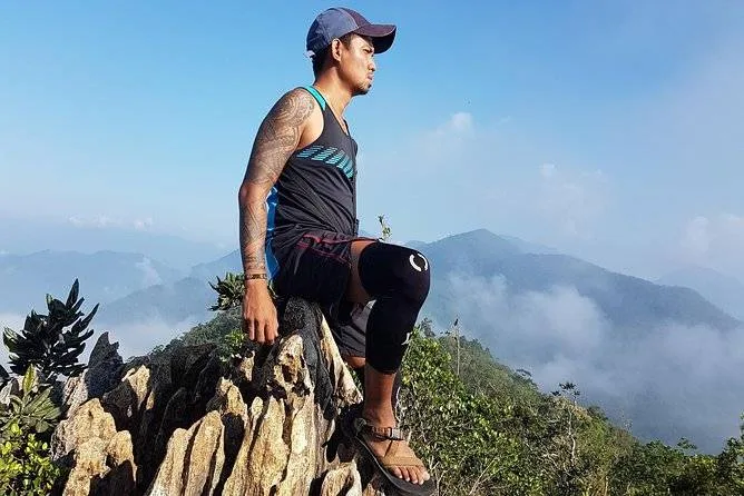 man sitting on rock in mountains
