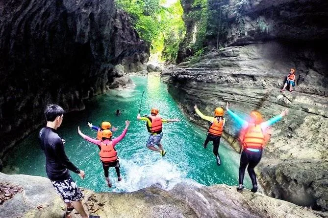 4 people jumping off cliff to ocean